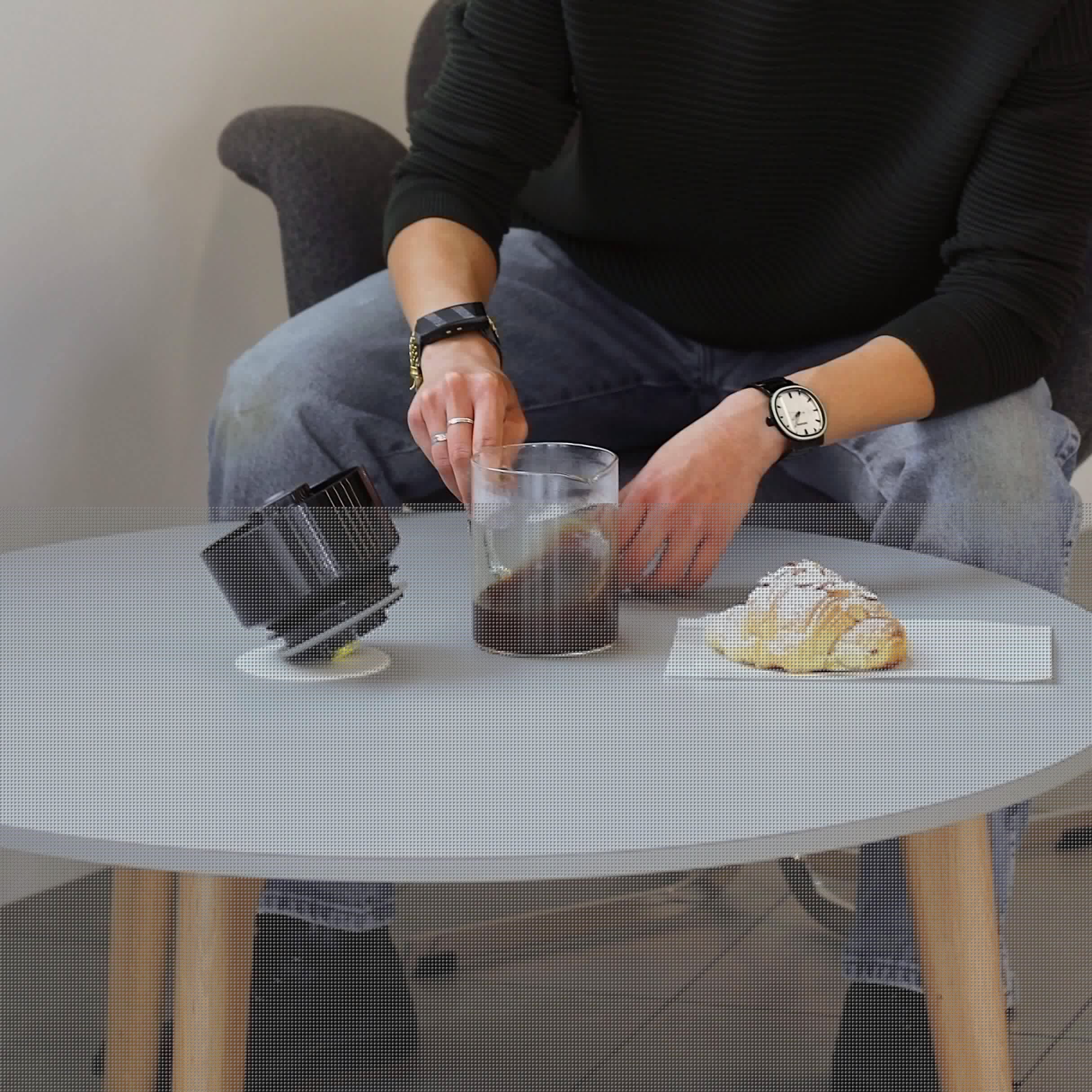Close-up of Karine Ng's hand swirling the VacOne carafe of coffee